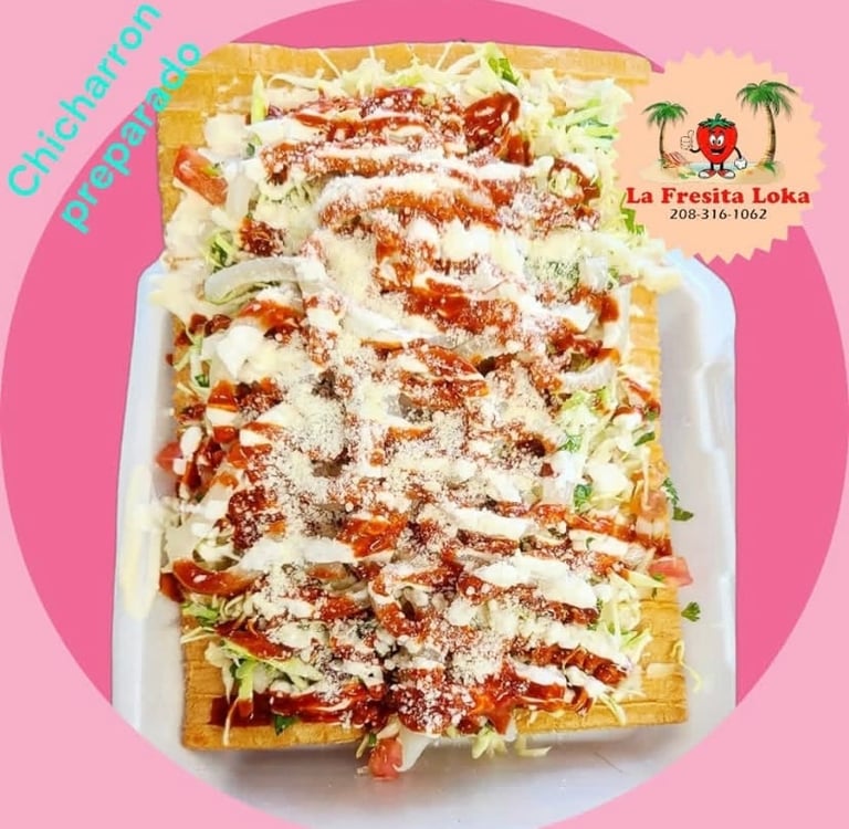 Enchiladas verdes topped with sour cream drizzle, crumbled red sauce, and fresh lettuce on a pink background with restaurant branding