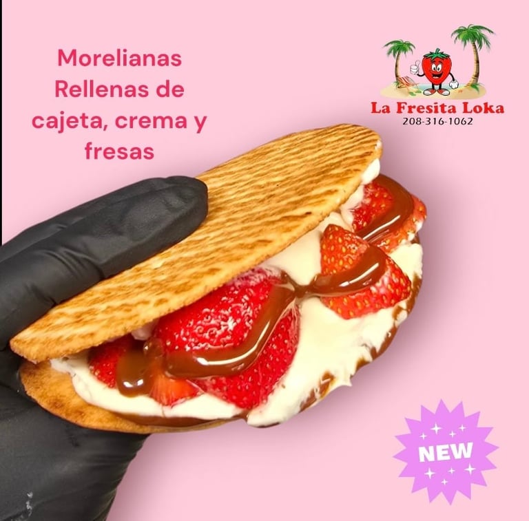 Hand holding pastry with cream and fresh strawberries against pink background with text and logo for La Fresita Loka