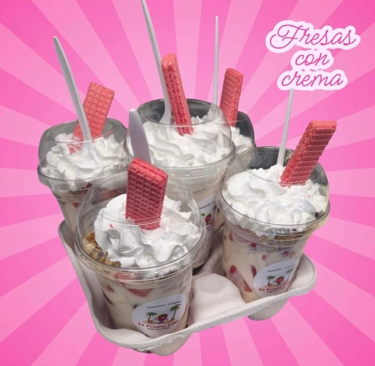 Four creamy dessert cups with wafer cookies on a pink starburst background, labeled Fresas con crema