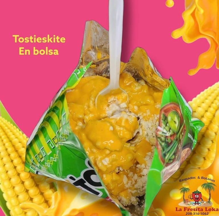 Tostieskite corn snack product in green and white packaging being pulled open, revealing golden crispy contents against pink background