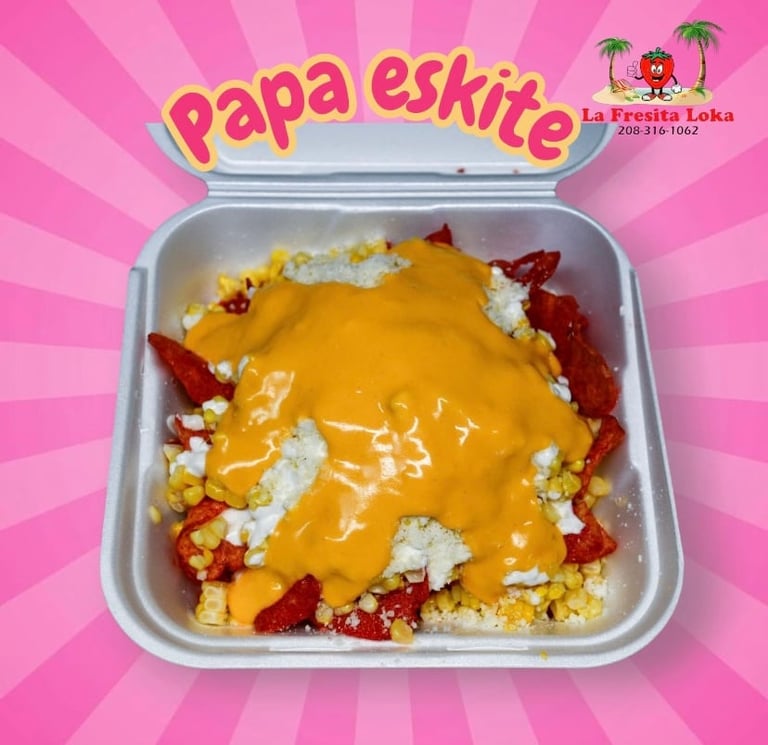 Papa Eskite dish in white container with yellow cheese sauce, diced red peppers, and cauliflower on pink background